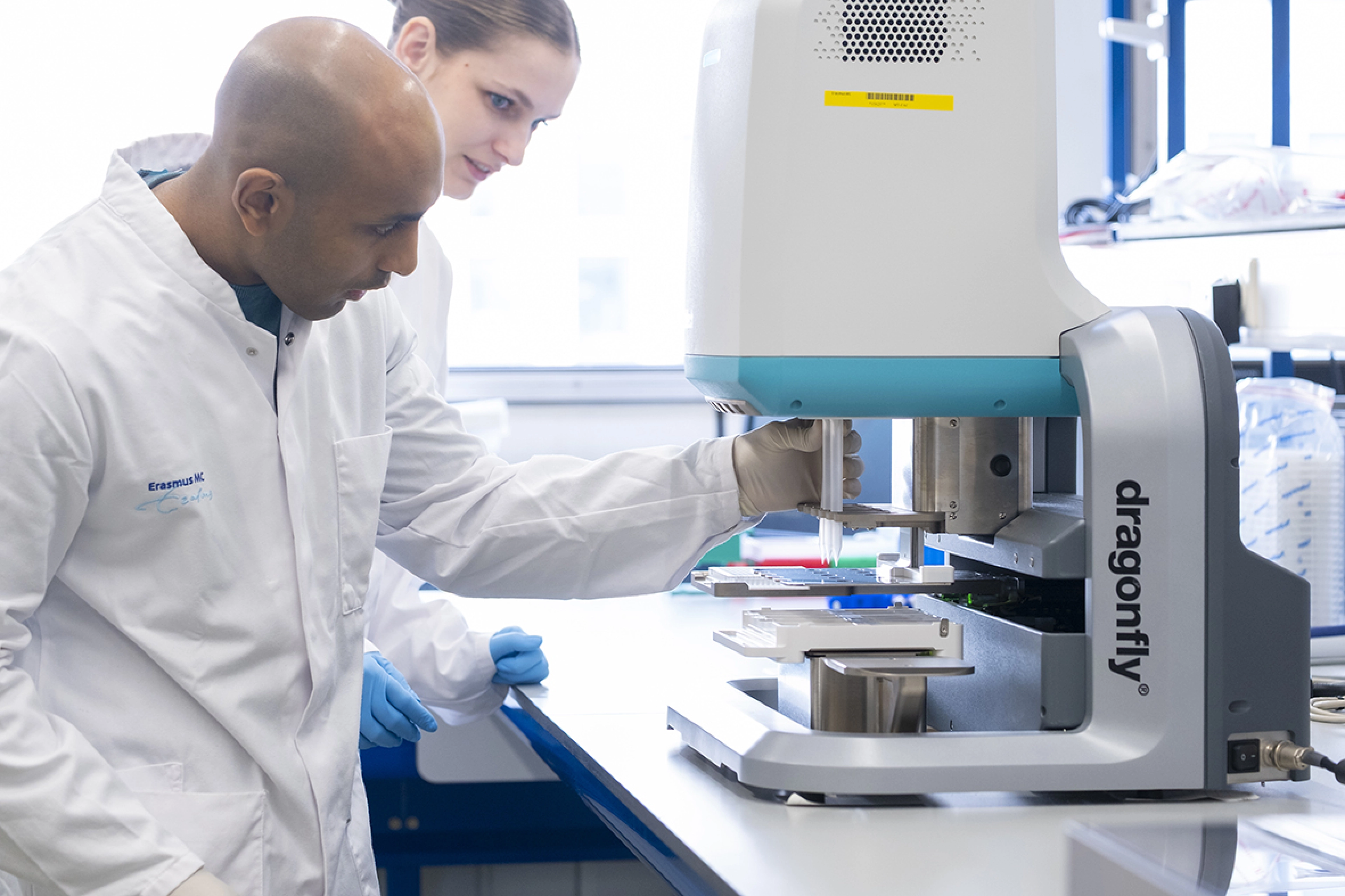 Two technicans (man and woman) working with proteomics equipment in a laboratory.