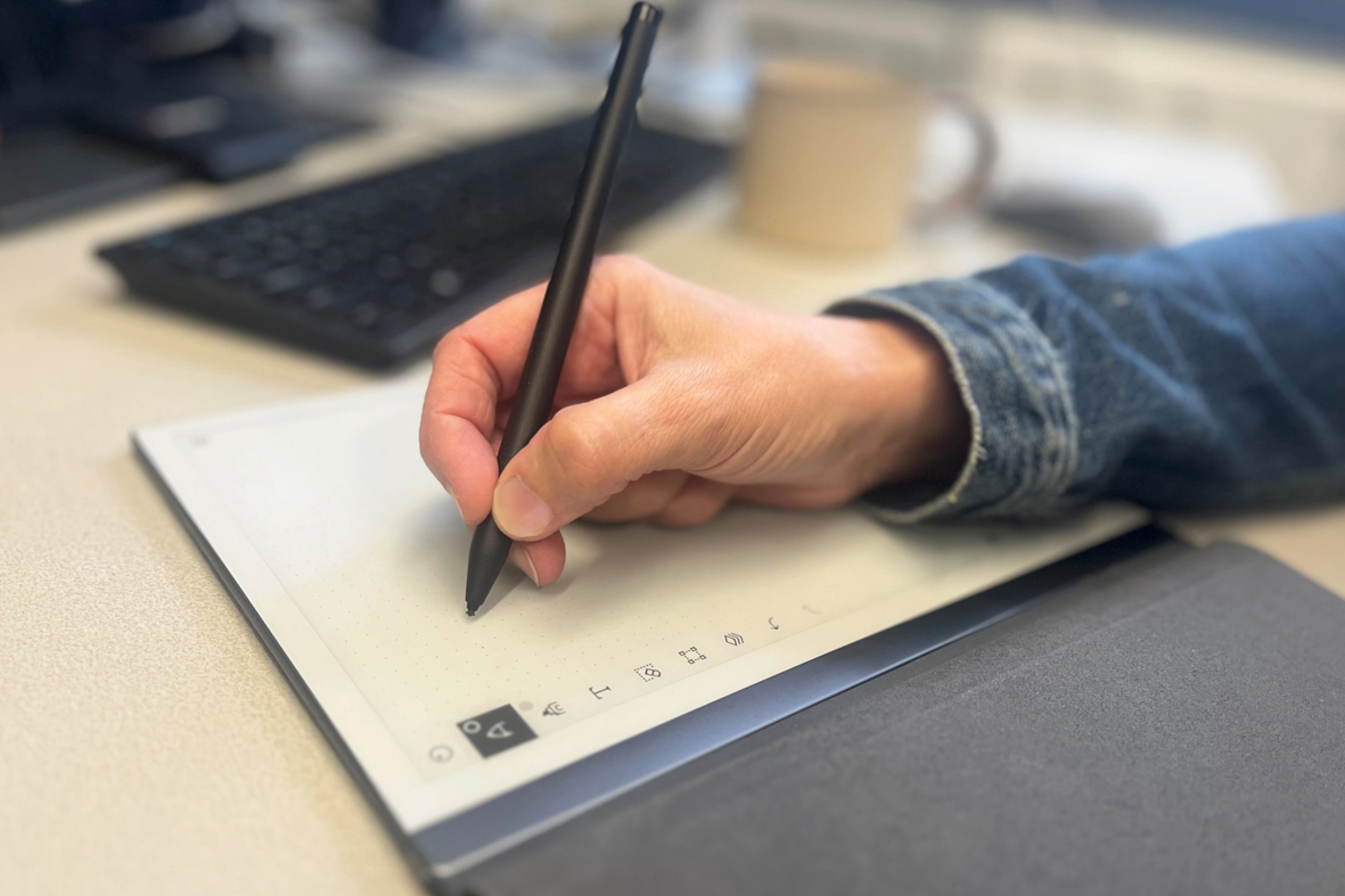 Close-up of a hand holding a pen while writing.